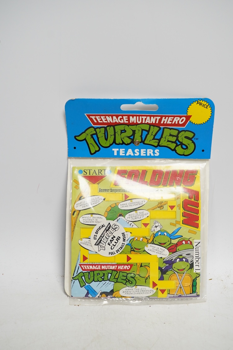 A Playmates Teenage Mutant Ninja Turtles figure of Michaelangelo, dated 1988, a Teenage Mutant Hero Turtles packeted ‘Teasers’, dated 1990, and a Matchbox Ring Raiders toy. Condition - fair to good, some creases to backi